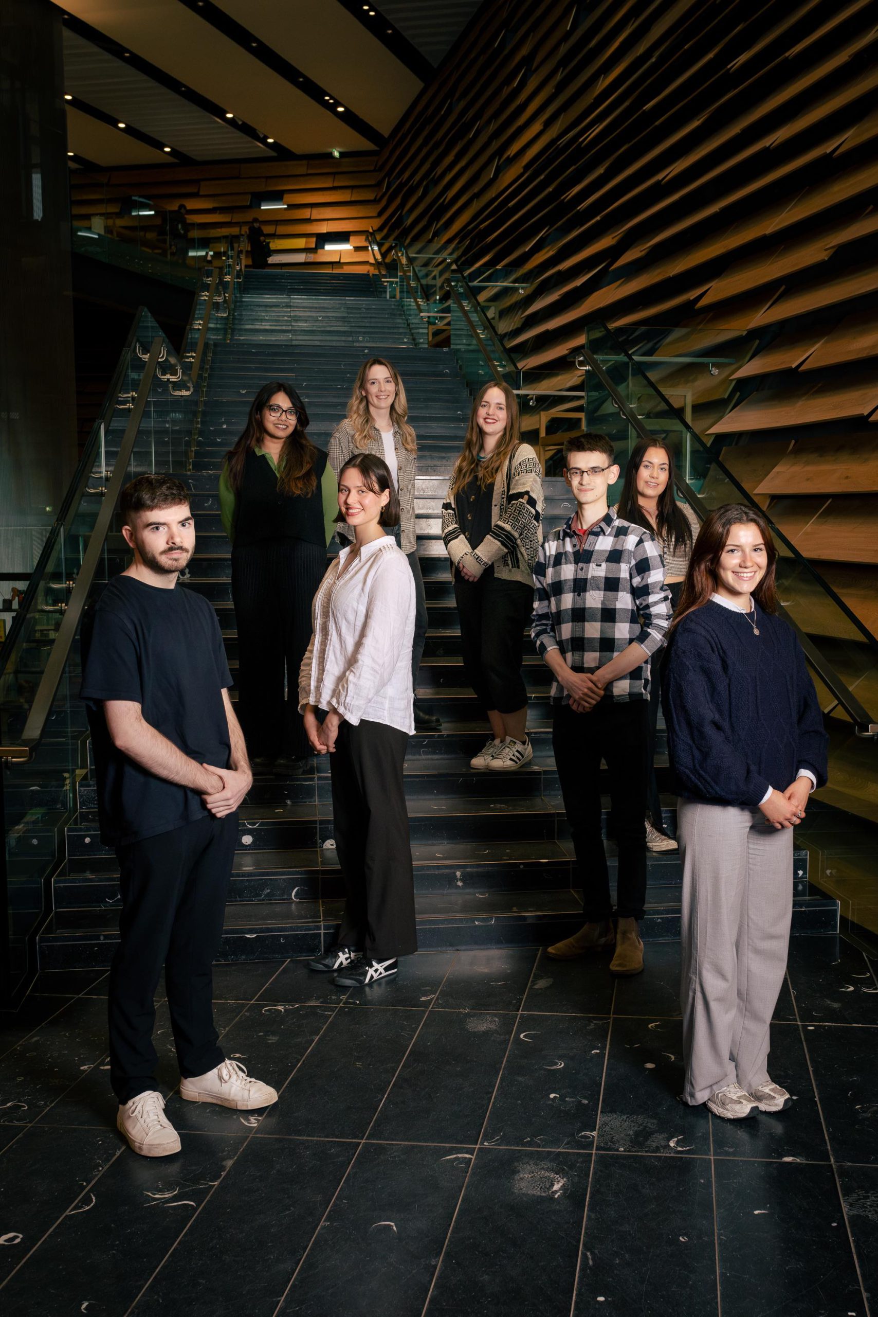 A group of people stand in a staircase in the V&A Dundee